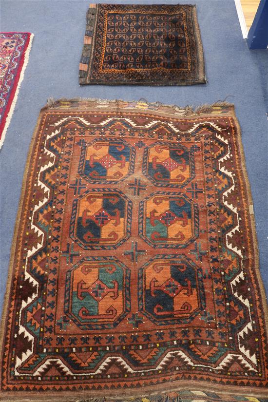 A Persian rust ground rug and a saddlebag, 130 x 100cm